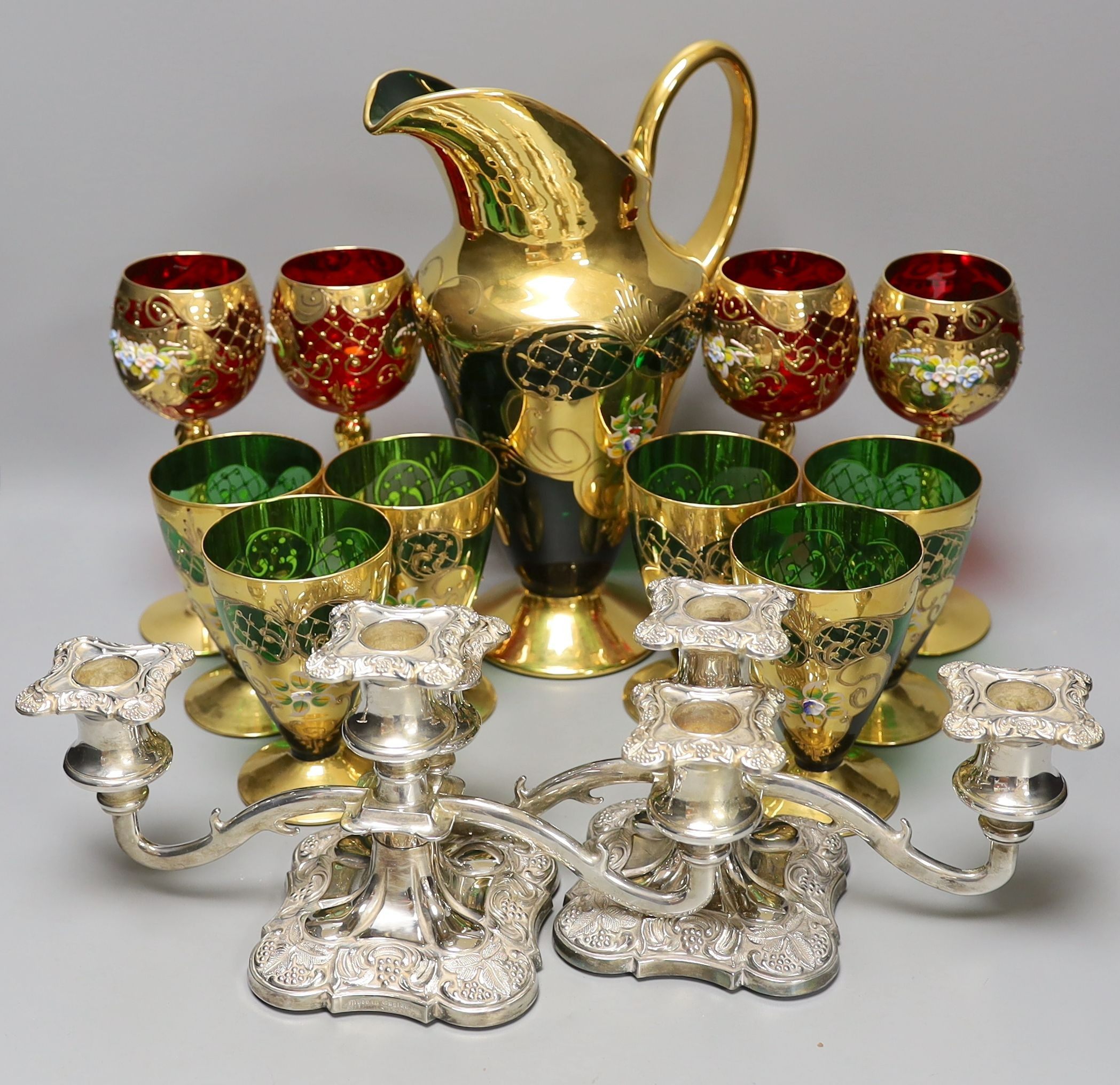 A Venetian green glass lemonade set, 4 red glass wine glasses and a pair of plated candelabra, jug 29 cms high.